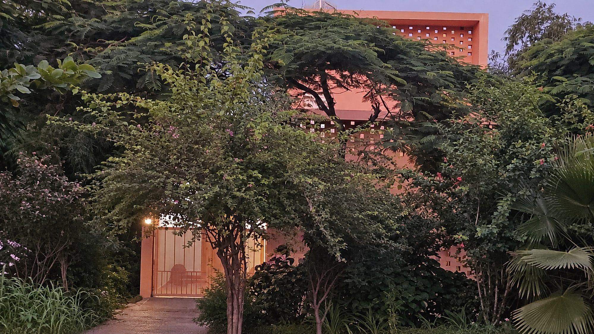 Shantiniketan at dusk, almost hidden behind a garden of trees