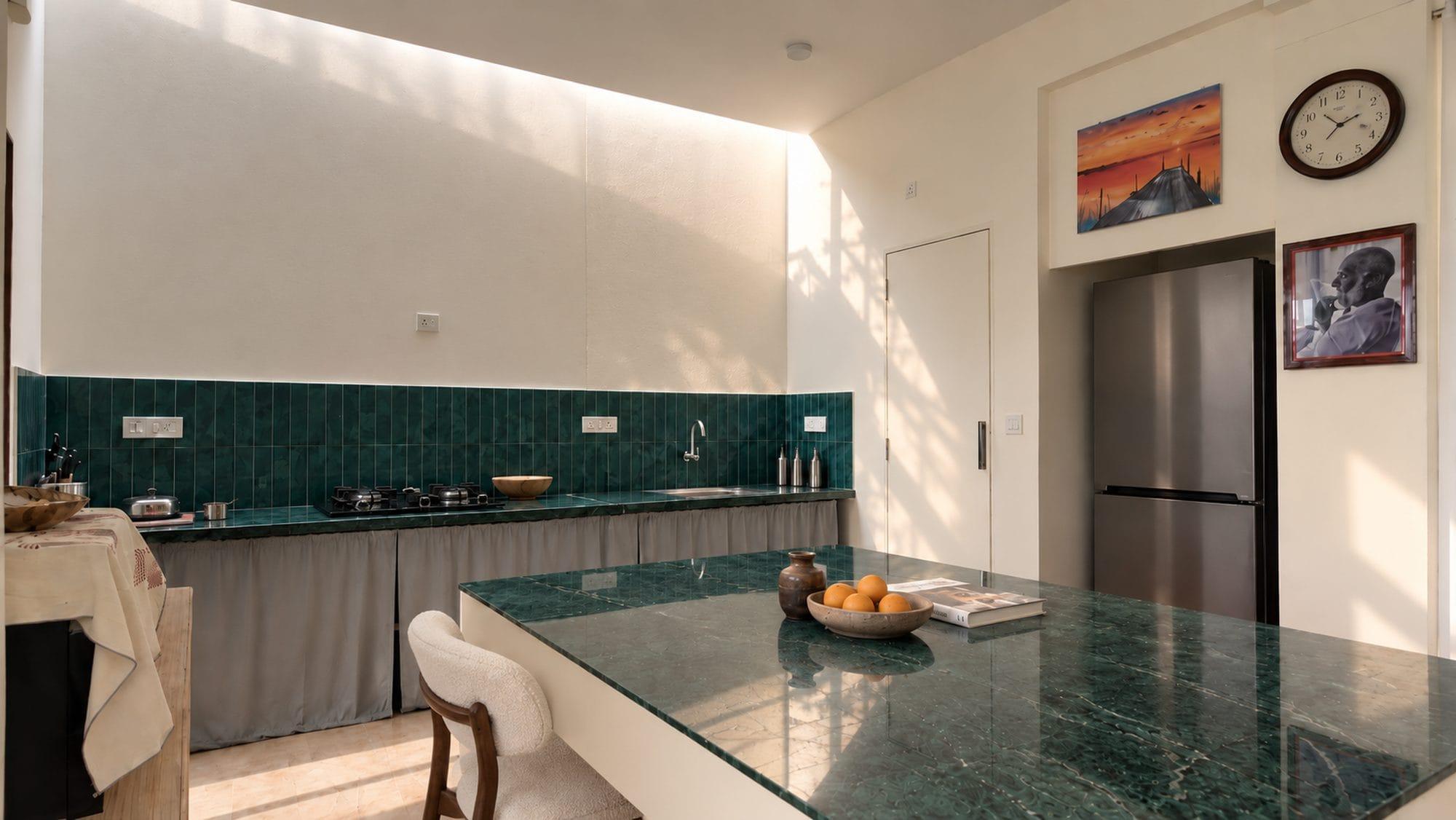 Kitchen with green tiles and a marble island under a skylight